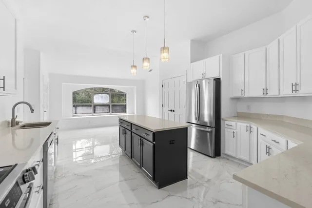 a large white kitchen with a large window