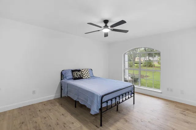 an empty room with windows and fan