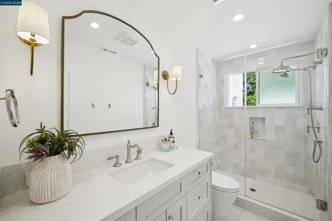 a bathroom with a granite countertop sink a toilet and shower