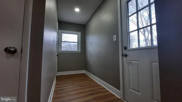 a view of a hallway with wooden floor and windows