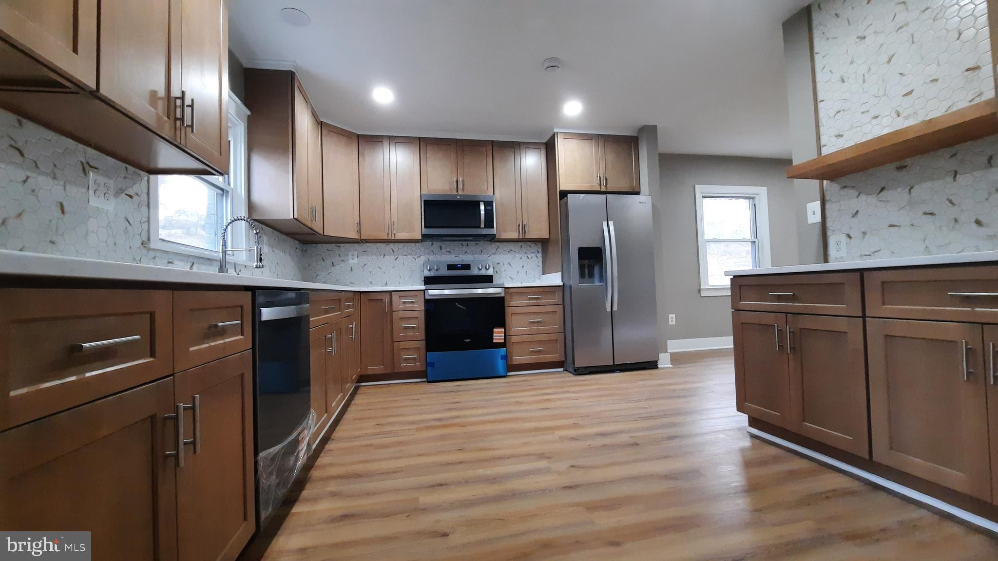 373 Bowman Road Front Royal, VA 22630 - Photo 8 of 28 a kitchen with stainless steel appliances granite countertop wooden cabinets a refrigerator a sink a stove and a wooden floors