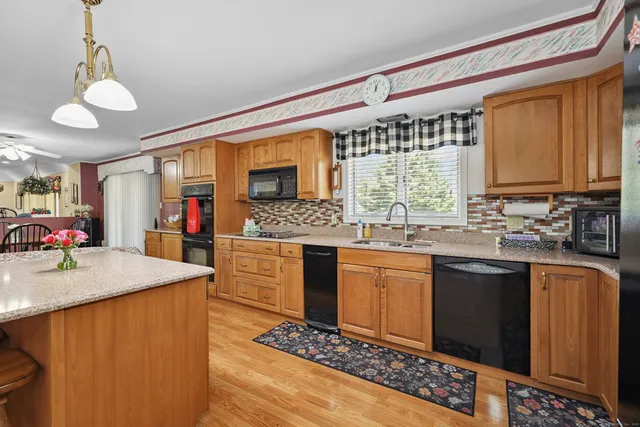 a kitchen with stainless steel appliances kitchen island granite countertop a sink stove and cabinets