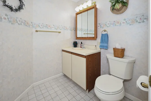 a bathroom with a toilet a sink and a mirror