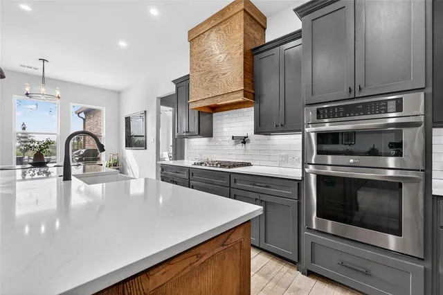 a kitchen with stainless steel appliances a sink stove and refrigerator