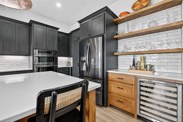 a kitchen with stainless steel appliances a stove a sink a microwave and cabinets