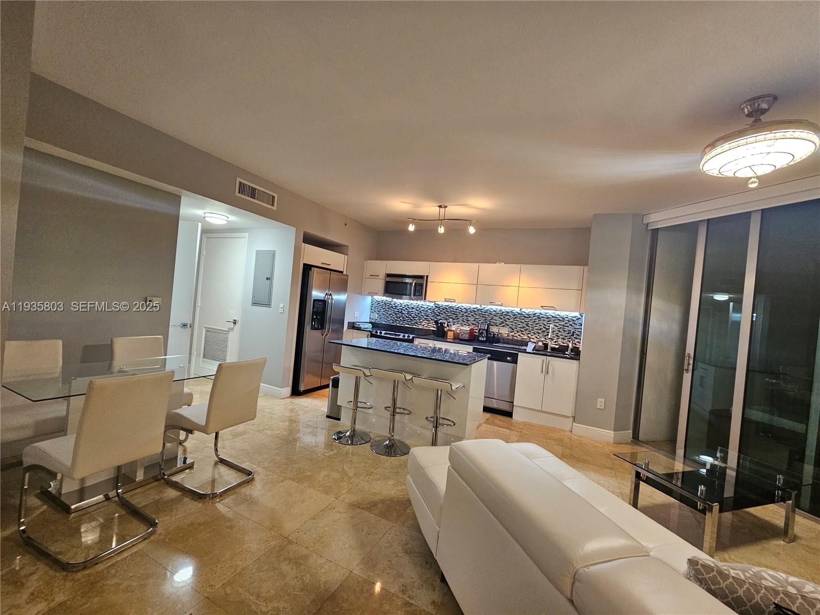 41 Southeast 5th Street, Unit 1517 Miami, FL 33131 - Photo 12 of 50 a living room with furniture a flat screen tv and a large window