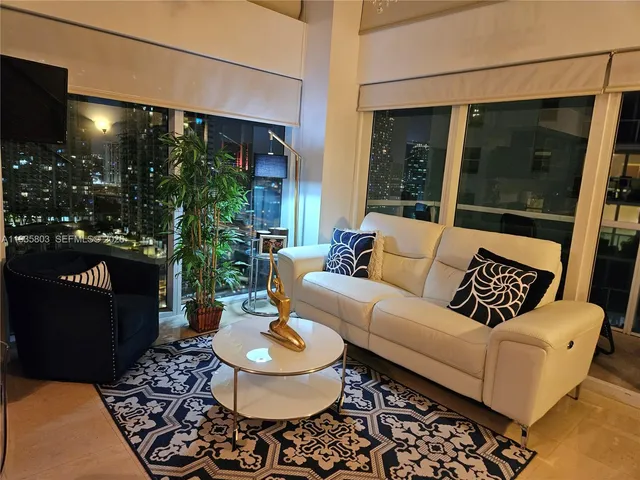 a living room with furniture and a potted plant