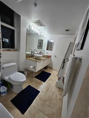 a bathroom with a toilet a sink and mirror