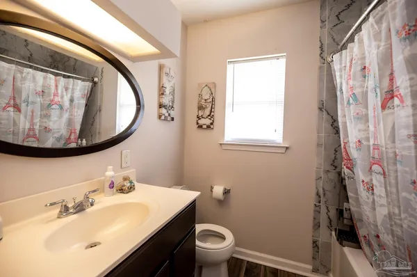 a bathroom with a sink and mirror with toilet
