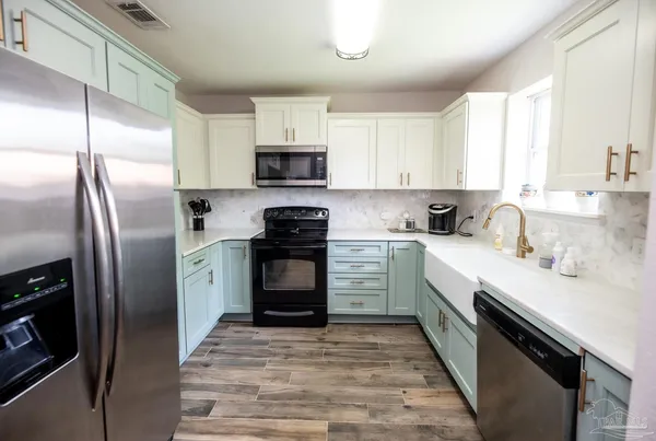 a kitchen with stainless steel appliances a refrigerator sink and cabinets