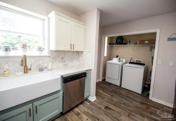 a utility room with cabinets washer and dryer