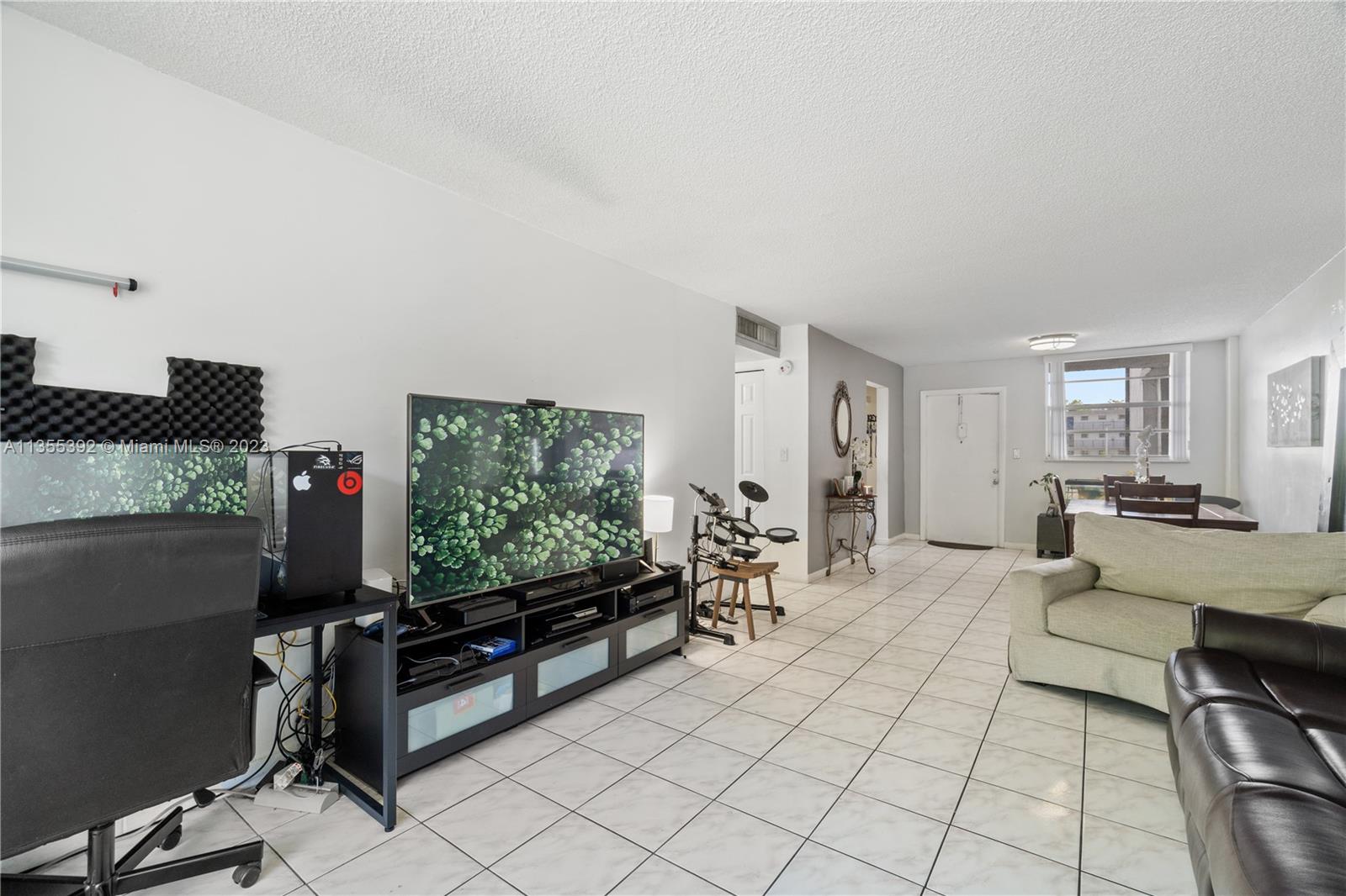 14140 Southwest 84th Street, Unit 208H Miami, FL 33183 - Photo 5 of 29 a living room with furniture a flat screen tv and a window