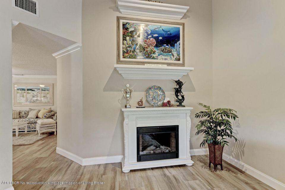18905 Southeast County Line Road Jupiter, FL 33469 - Photo 12 of 74 a living room with a fireplace and wooden floor