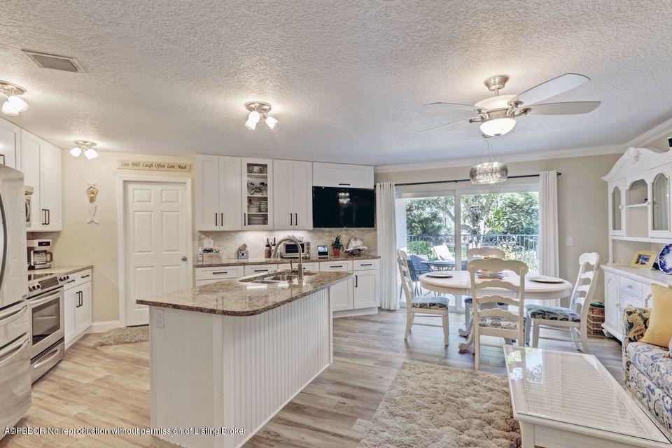 18905 Southeast County Line Road Jupiter, FL 33469 - Photo 14 of 74 a large kitchen with kitchen island a large counter space appliances and a dining table