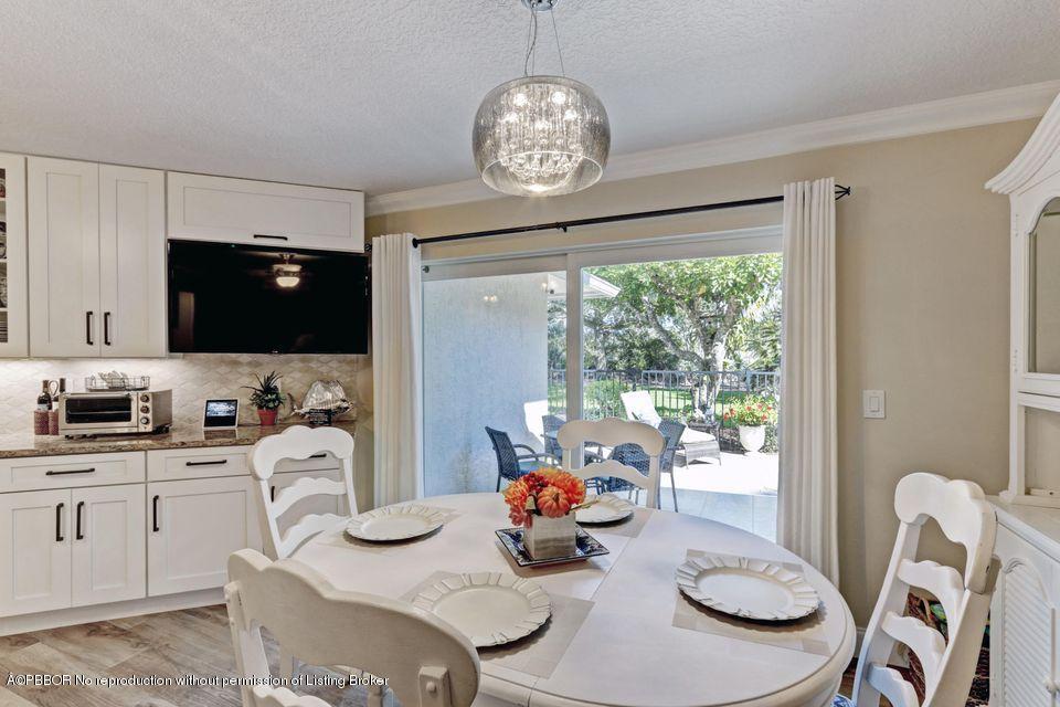 18905 Southeast County Line Road Jupiter, FL 33469 - Photo 17 of 74 a view of a dining room with furniture a chandelier and kitchen view