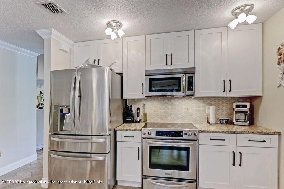 18905 Southeast County Line Road Jupiter, FL 33469 - Photo 20 of 74 a kitchen with refrigerator a microwave a stove and cabinets