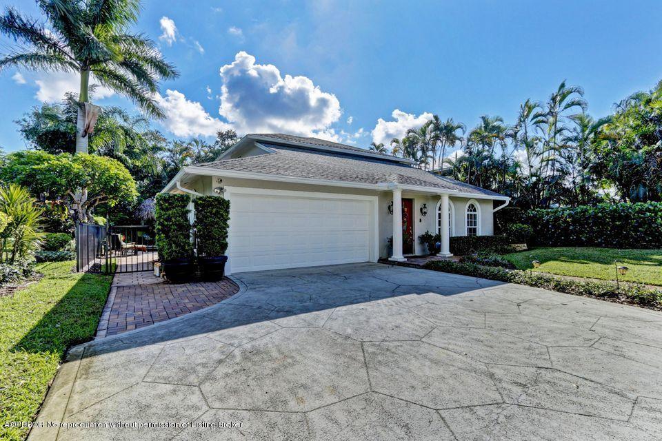 18905 Southeast County Line Road Jupiter, FL 33469 - Photo 3 of 74 a front view of a house with a yard and a garage
