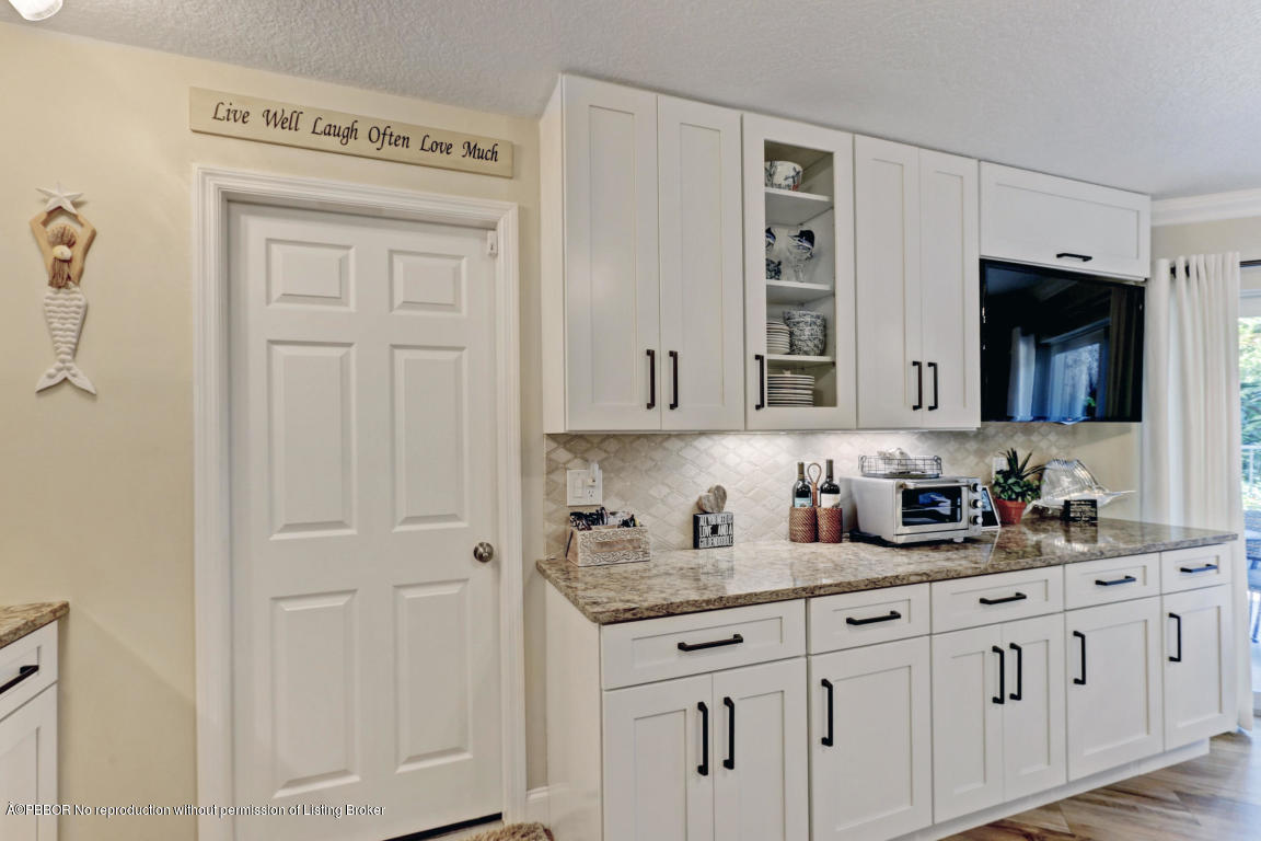 18905 Southeast County Line Road Jupiter, FL 33469 - Photo 22 of 74 a bathroom with cabinets two mirror a window and a sink