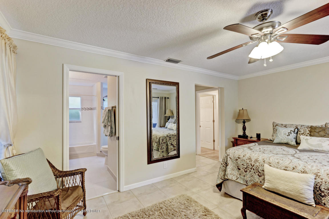 18905 Southeast County Line Road Jupiter, FL 33469 - Photo 27 of 74 a bedroom with a bed and a chandelier