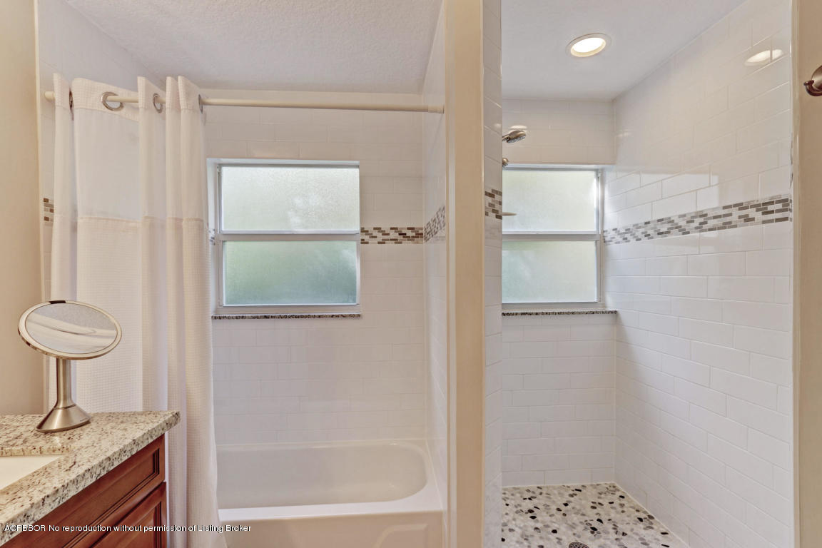 18905 Southeast County Line Road Jupiter, FL 33469 - Photo 29 of 74 a bathroom with a granite countertop shower a sink and a toilet