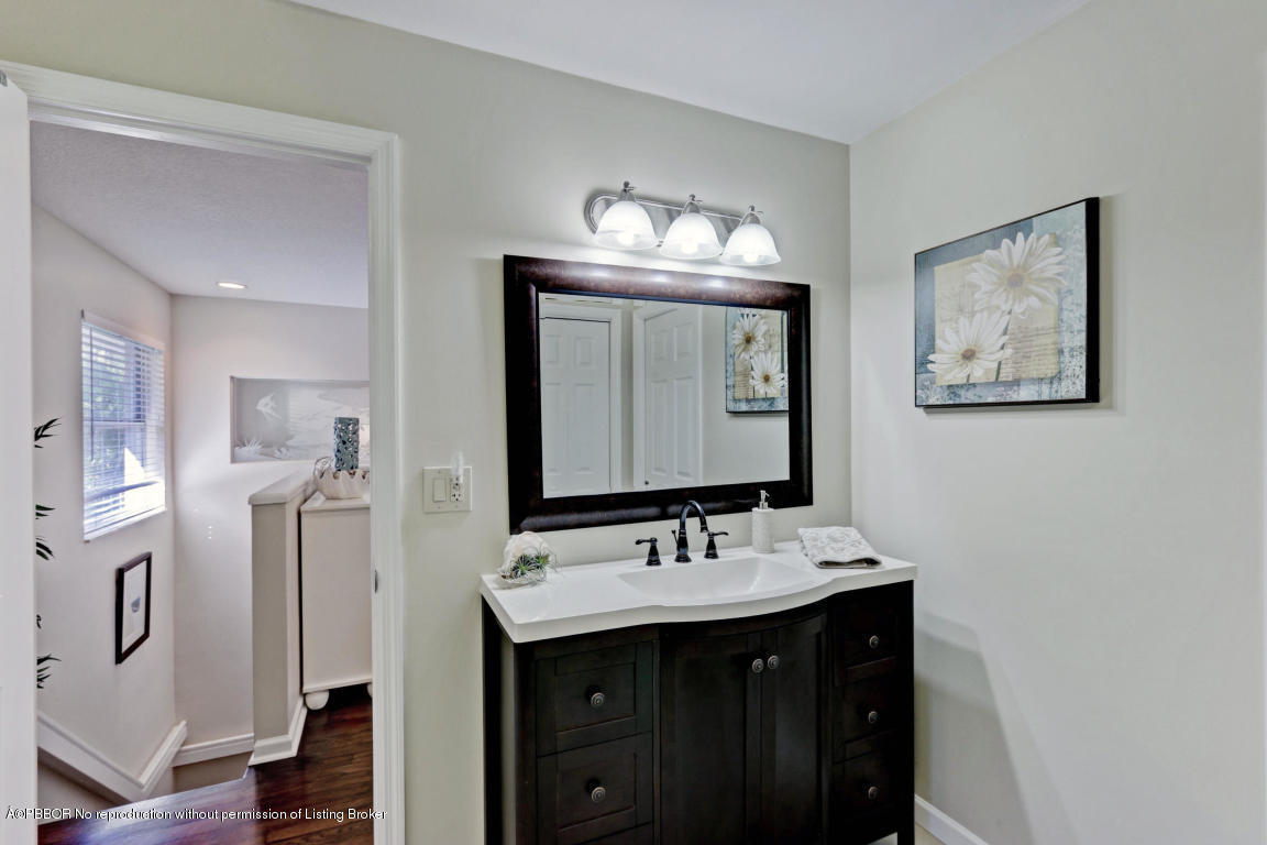 18905 Southeast County Line Road Jupiter, FL 33469 - Photo 35 of 74 a bathroom with a double vanity sink and a mirror