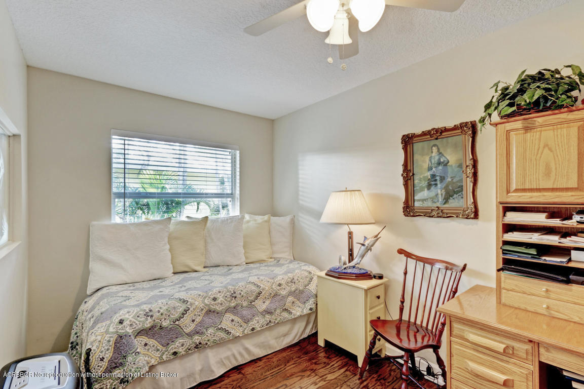 18905 Southeast County Line Road Jupiter, FL 33469 - Photo 38 of 74 a bedroom with a bed and a chandelier