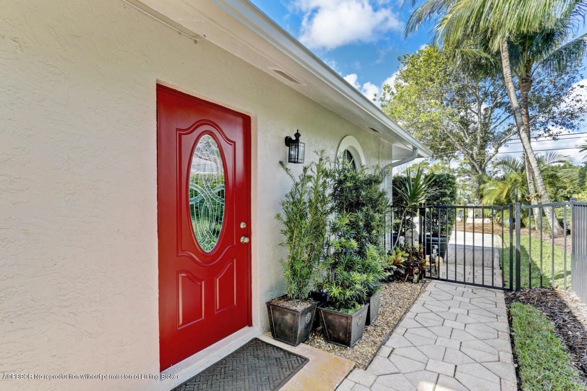 18905 Southeast County Line Road Jupiter, FL 33469 - Photo 59 of 74 a front view of a house with garden