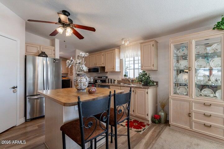 201 South Greenfield Road, Unit 176 Mesa, AZ 85206 - Photo 20 of 61 a kitchen with stainless steel appliances kitchen island granite countertop a refrigerator a stove a sink a dining table and chairs with wooden floor