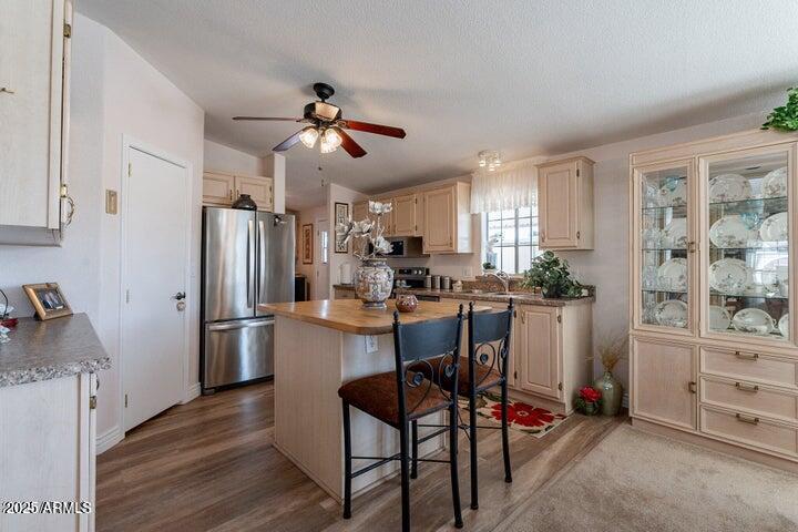201 South Greenfield Road, Unit 176 Mesa, AZ 85206 - Photo 21 of 61 a kitchen with stainless steel appliances kitchen island granite countertop a refrigerator a stove a dining table and chairs with wooden floor