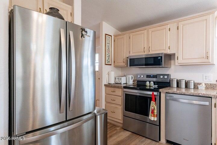 201 South Greenfield Road, Unit 176 Mesa, AZ 85206 - Photo 24 of 61 a kitchen with stainless steel appliances a refrigerator stove and white cabinets