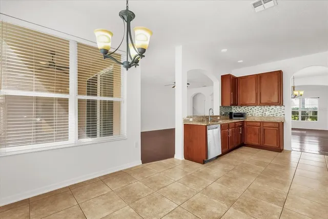 a large kitchen with stainless steel appliances granite countertop a stove sink and cabinets