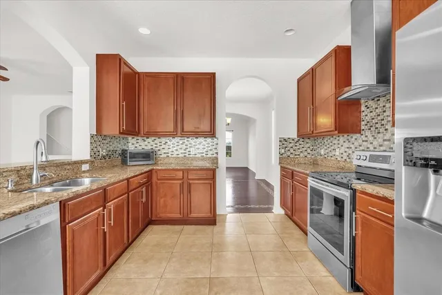 a large kitchen with granite countertop a sink and a stove