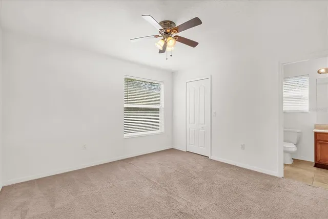 an empty room with a ceiling fan and a window