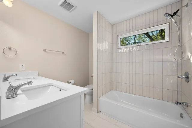 a bathroom with a tub a sink and a window