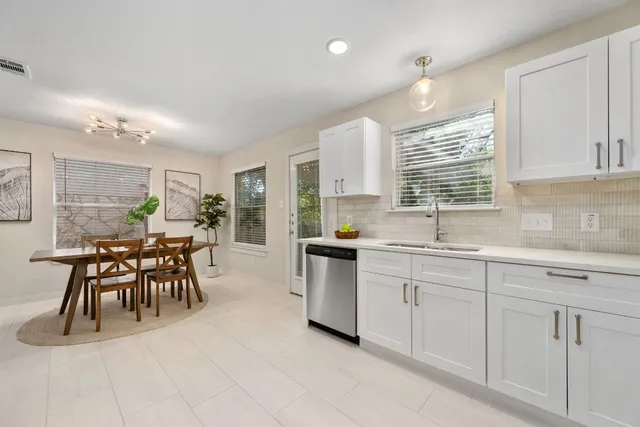 a kitchen with microwave a sink and chairs in it
