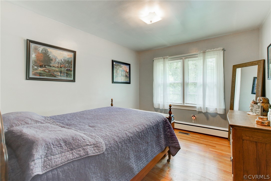 18506 Beaver Dam Road Beaverdam, VA 23015 - Photo 17 of 44 a spacious bedroom with a large bed and a chandelier
