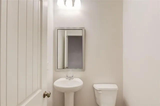a bathroom with a toilet sink and mirror