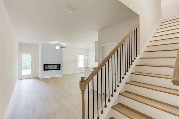 a view of staircase with wooden floor and pendant lights