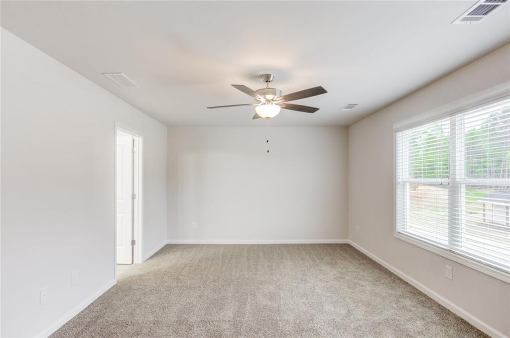 6334 Pine Ridge Point Lula, GA 30554 - Photo 18 of 32 an empty room with windows and fan