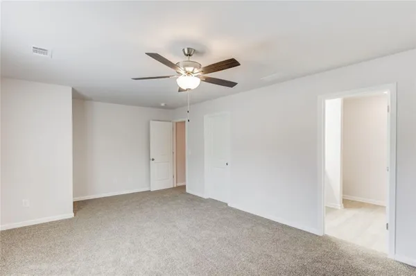 an empty room with a ceiling fan and a window