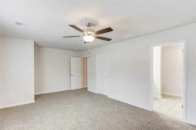 an empty room with a ceiling fan and a window