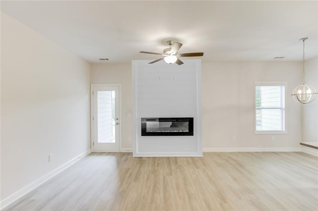 6334 Pine Ridge Point Lula, GA 30554 - Photo 7 of 32 an empty room with windows and chandelier fan