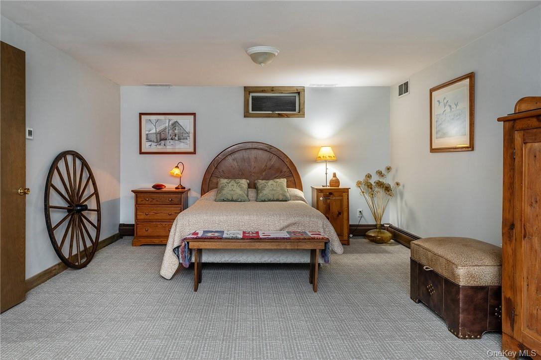 617 Bean River Road Pine Plains, NY 12546 - Photo 22 of 40 a bedroom with a bed and a chandelier