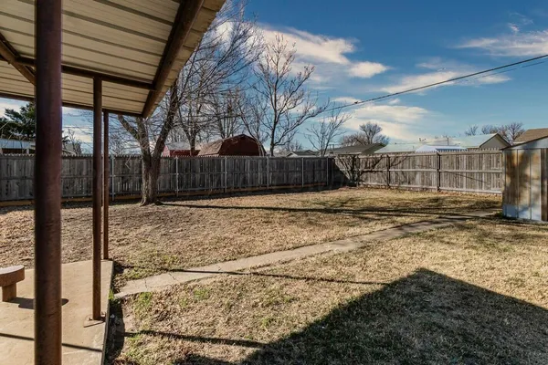 a view of a yard with wooden fence