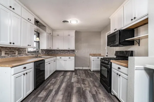 a kitchen with cabinets stainless steel appliances and sink