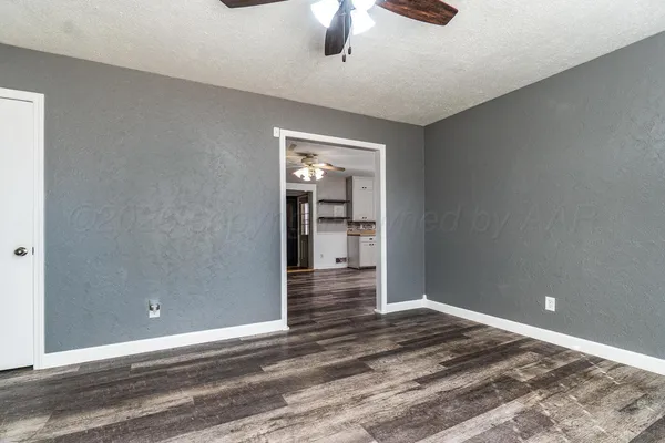 a view of a big room with wooden floor and windows