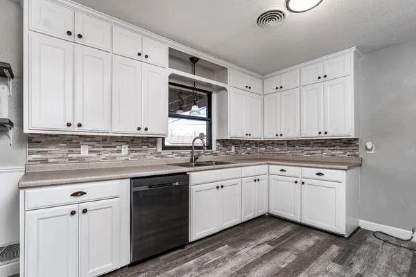 a kitchen with granite countertop a sink and cabinets
