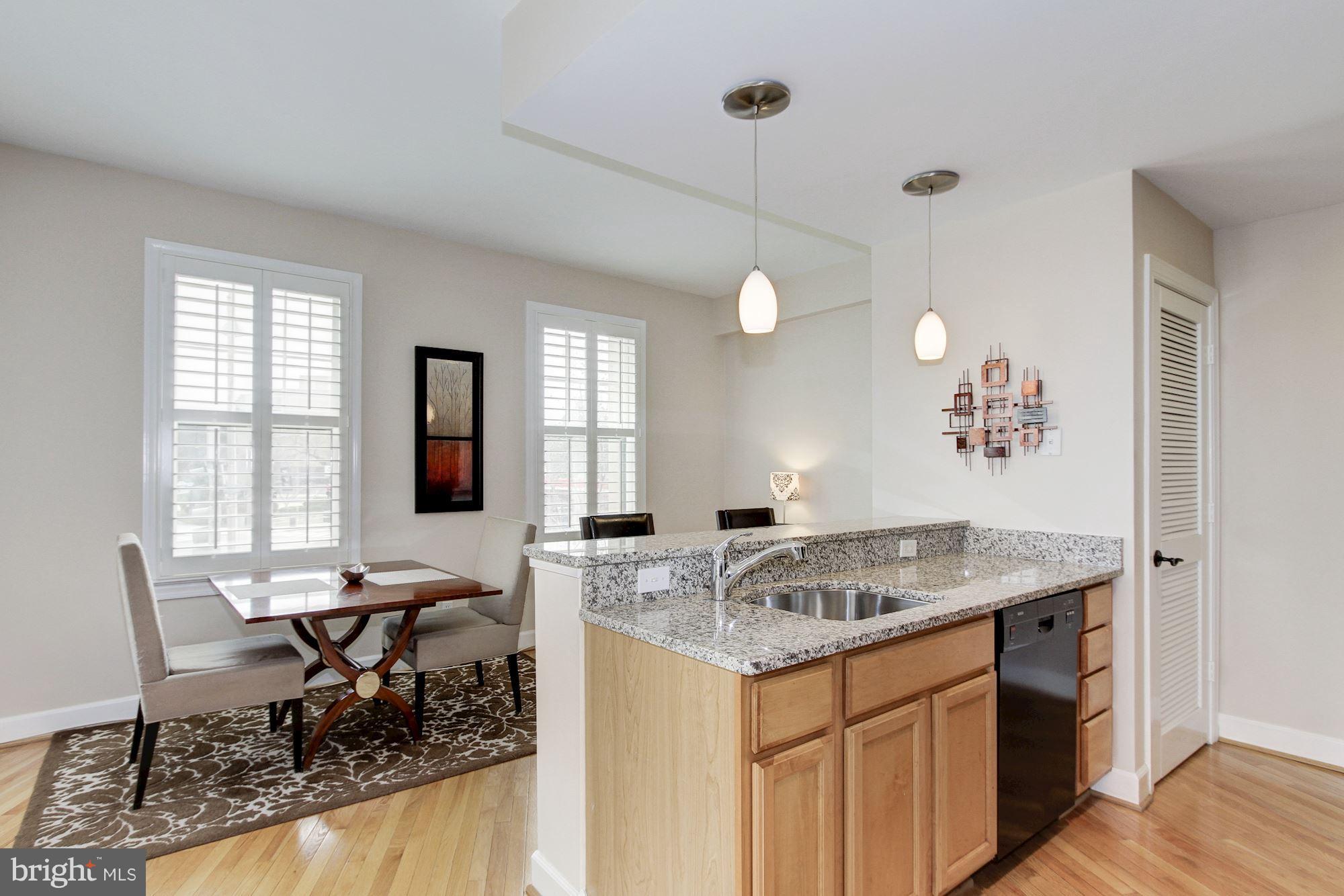 2902 Porter Street Northwest, Unit 21 Washington, DC 20008 - Photo 13 of 18 a kitchen with a table chairs and wooden floor