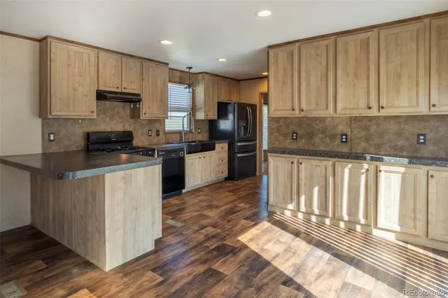 a kitchen with stainless steel appliances granite countertop a stove a sink and a refrigerator