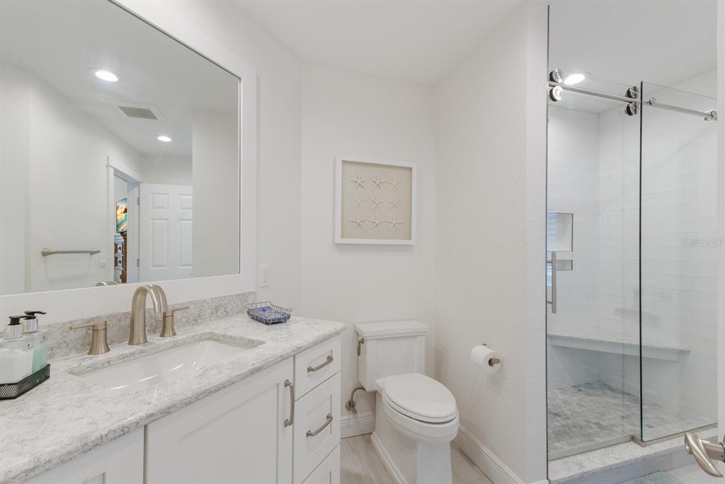 799 Beach View Drive Boca Grande, FL 33921 - Photo 13 of 77 a bathroom with a granite countertop sink a toilet and a mirror